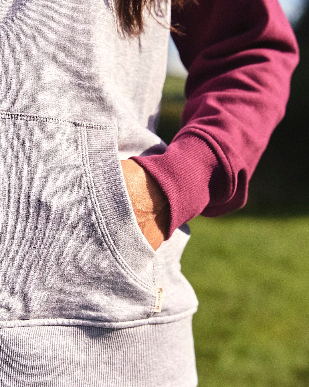 A woman wearing a warm Adventure Awaits - Womens Zip Hoodie - Light Grey by Saltrock, outdoors.