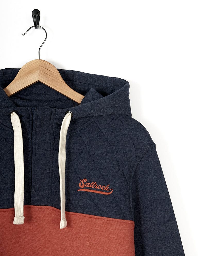 A Saltrock - Mens 1/4 Neck Hoodie - Orange hanging on a hanger.