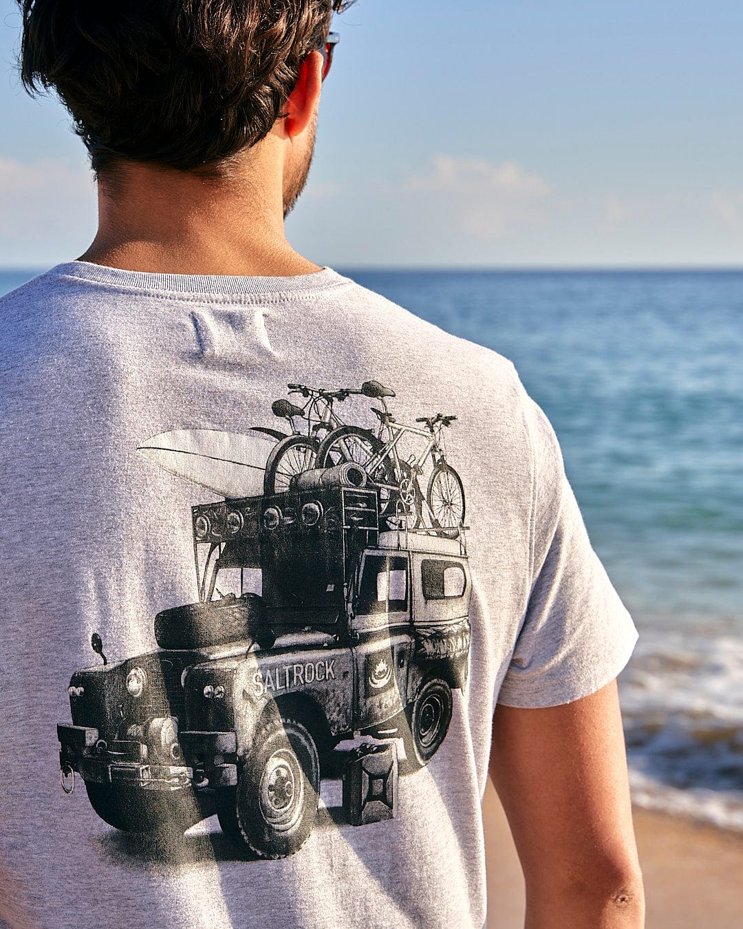 A man wearing a Saltrock All Terrain - Mens Short Sleeve T-Shirt - Grey with a truck on it.