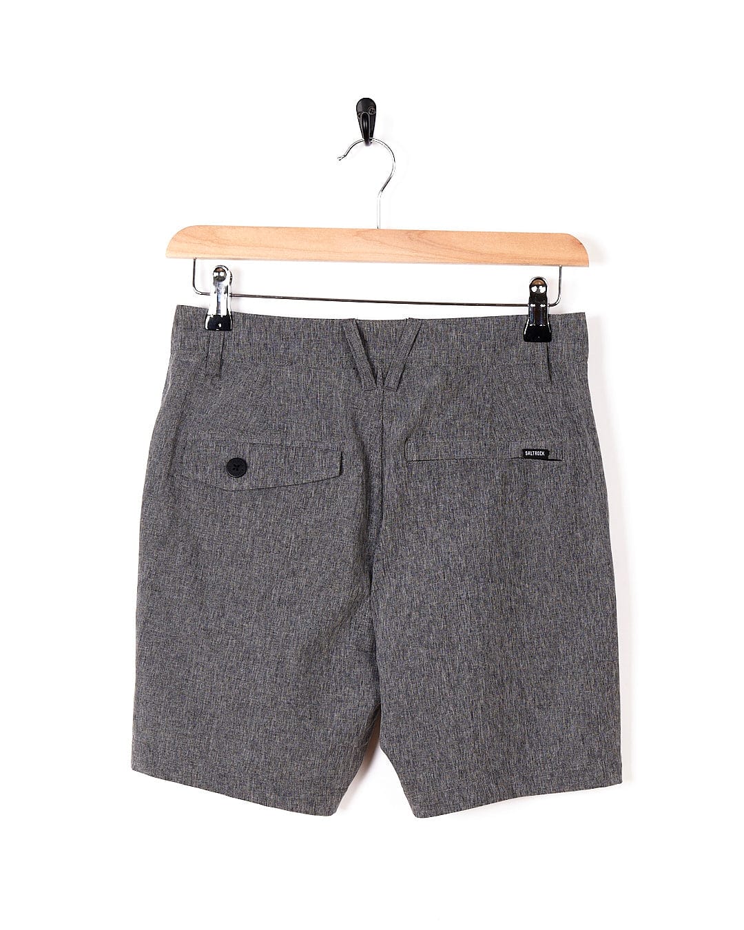 A pair of Saltrock Amphibian - Kids Boardshorts - Grey hanging on a wooden hanger.