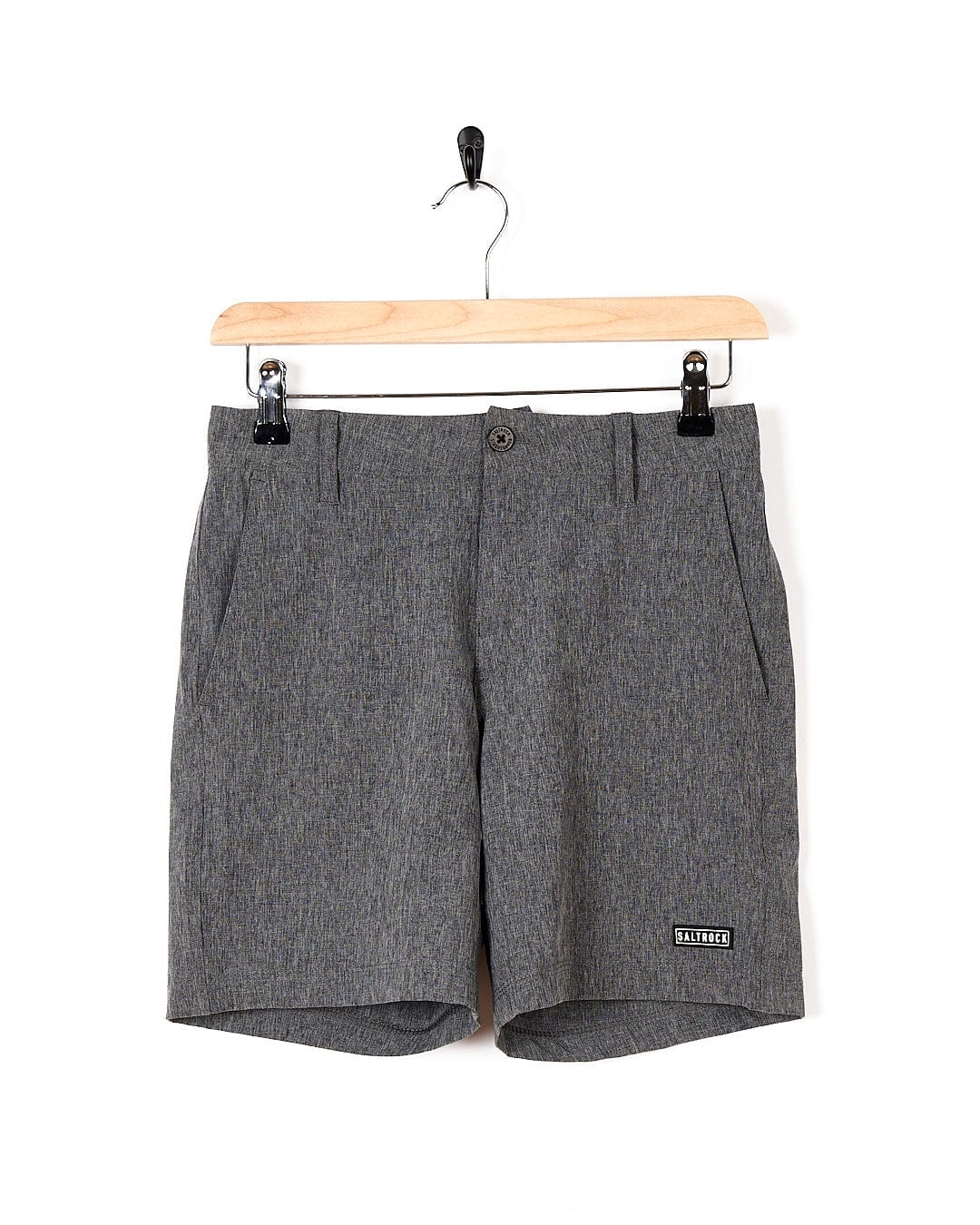 A pair of Saltrock Amphibian - Kids Boardshorts - Grey hanging on a wooden hanger.