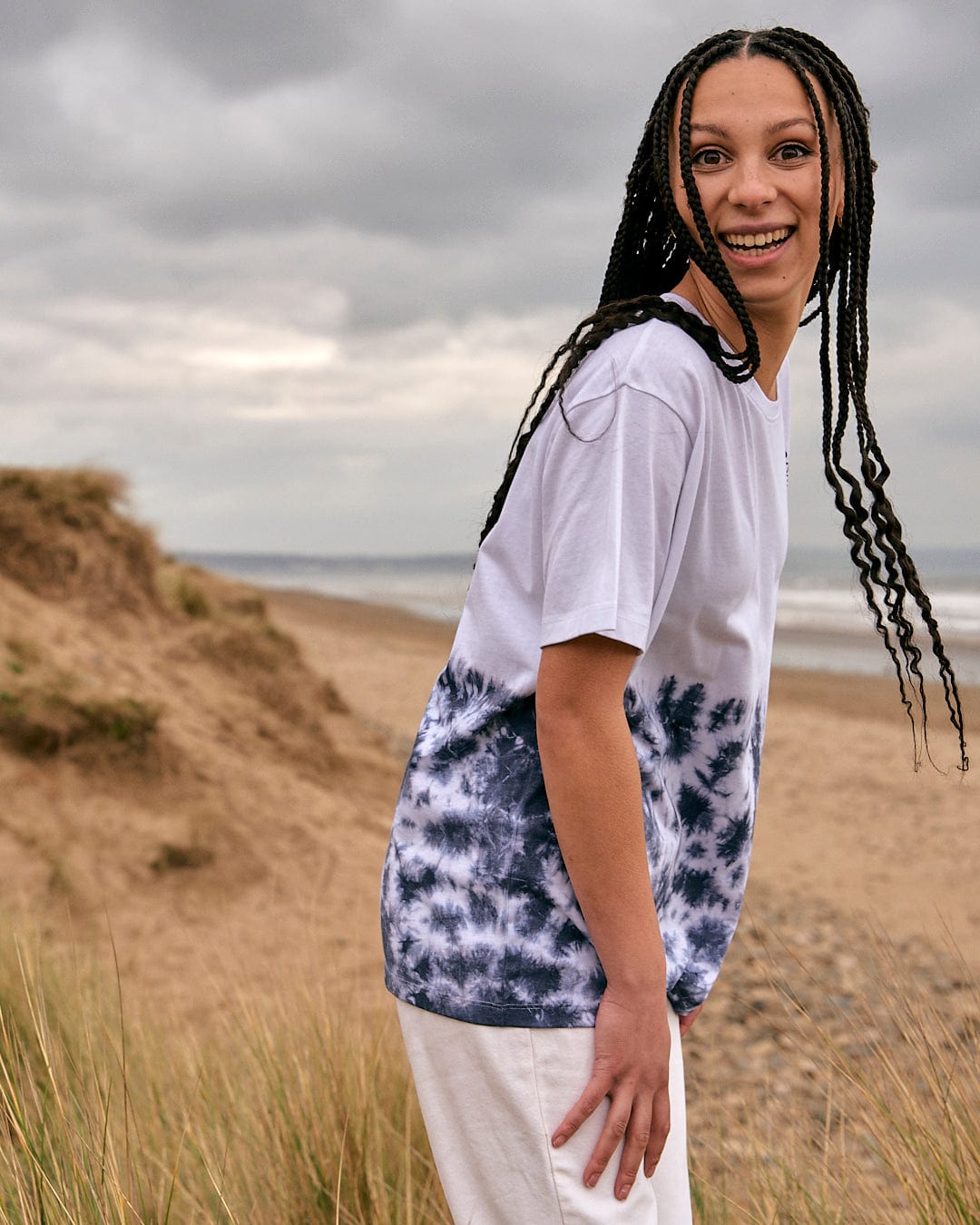 A woman wearing a Saltrock Astra Womens Short Sleeve T-Shirt - White standing on a beach.