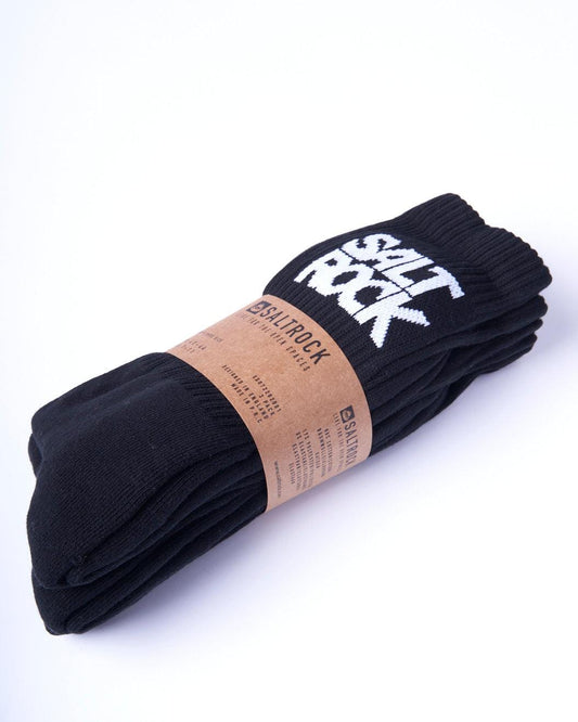 A pair of black, mid-calf length socks with "Salt Rock" printed on them, wrapped in brown packaging with the Saltrock brand label, made from warm material has been replaced by an Athletic 3 Pack of Socks - Black from Saltrock.