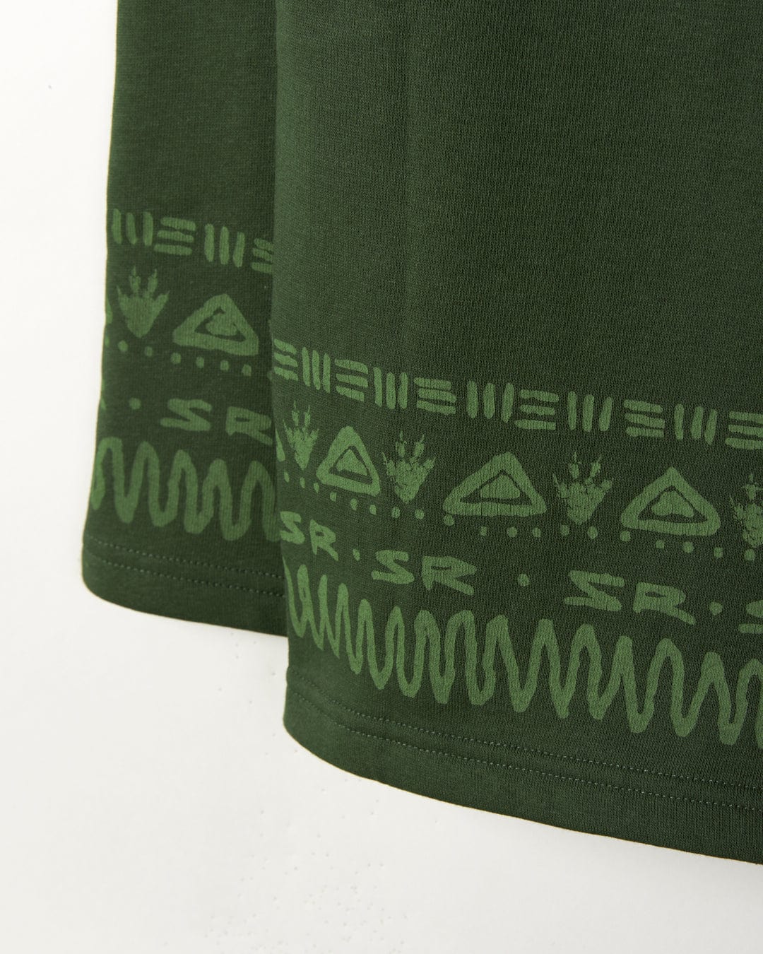 Close-up of a Back in the Day - Recycled Kids Pop Hoodie - Dark Green fabric with Aztec-inspired patterns in a lighter green at the hem by Saltrock.