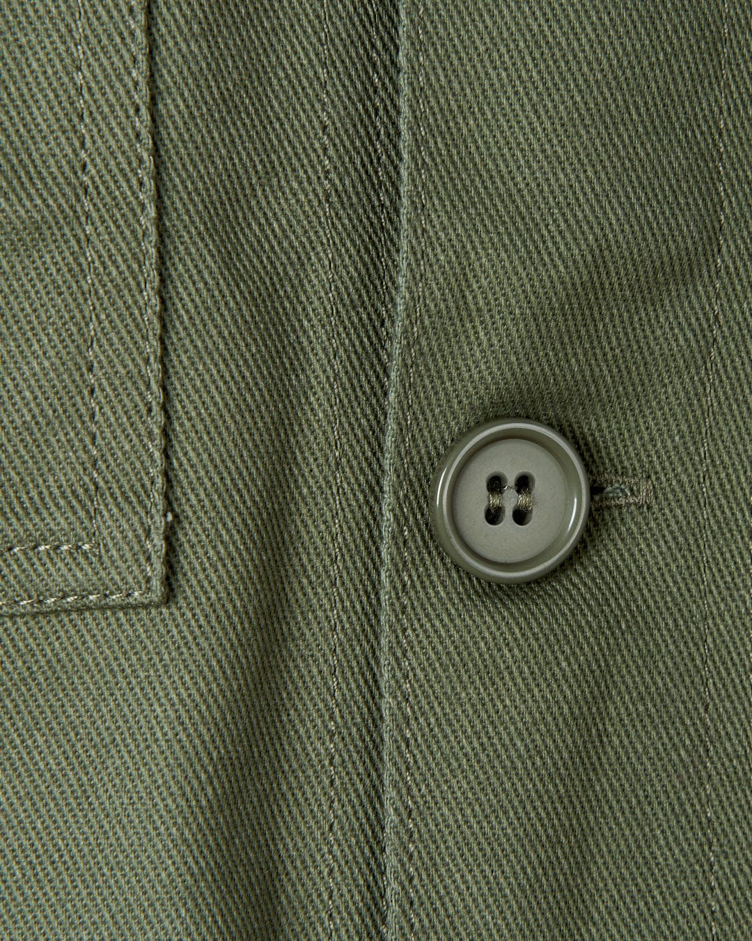 A close up of a button on a Saltrock Barden - Womens Lightweight Utility Jacket in Dark Green.