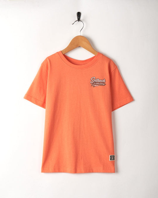 A child's orange Saltrock Kids Short Sleeve T-Shirt, made of 100% Cotton, hanging on a wooden hanger.