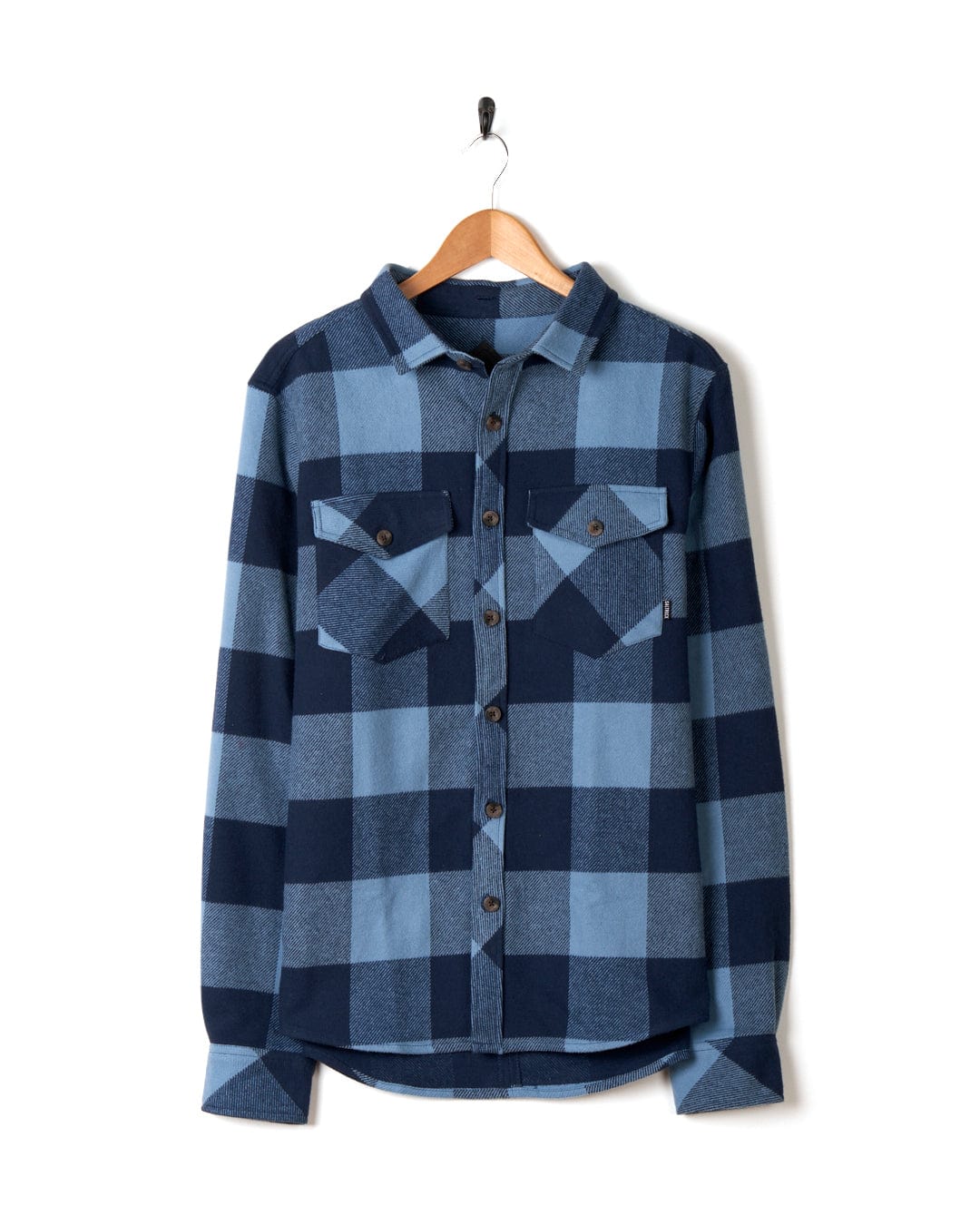 Beale - Mens Hooded Long Sleeve Shirt in Blue by Saltrock hanging on a hanger against a white background.