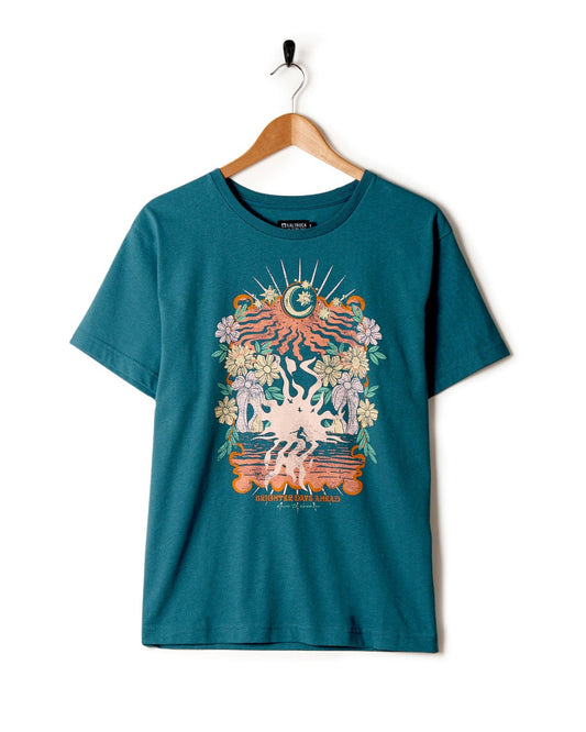A Better Days - Recycled Womens Short Sleeve Relaxed T-Shirt in teal from Saltrock with a colorful mystical graphic featuring the sun, moon, and nature elements, hanging on a wall-mounted coat hanger.
