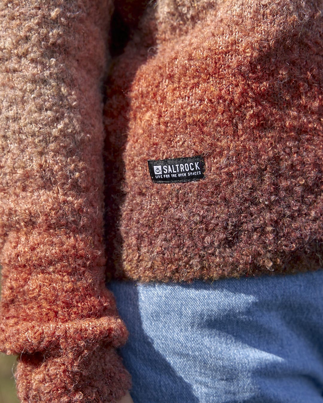 The back of a woman wearing the Saltrock Bowden - Boucle Crew Jumper - Orange sweater.