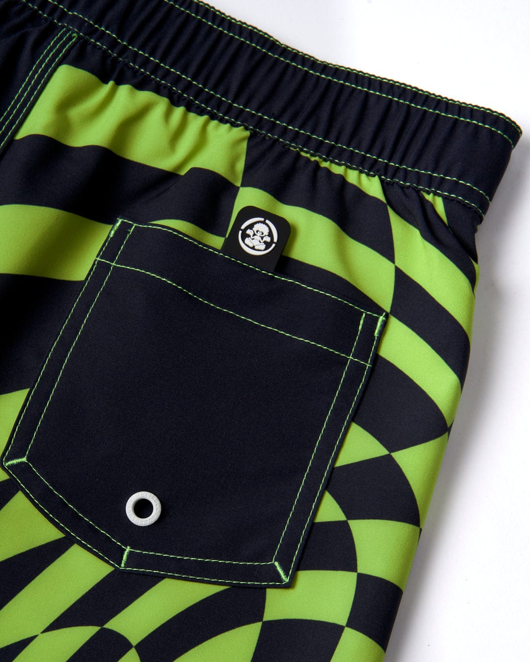 A green and black Saltrock board short with an elasticated waistband and a pocket. Made from Repreve Recycled material for sustainability.