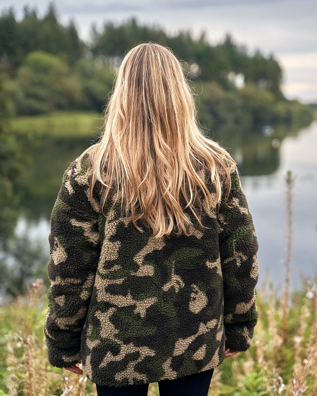 The back of a woman wearing a Saltrock Cirrus - Quilted Reversible Jacket - Dark Green.