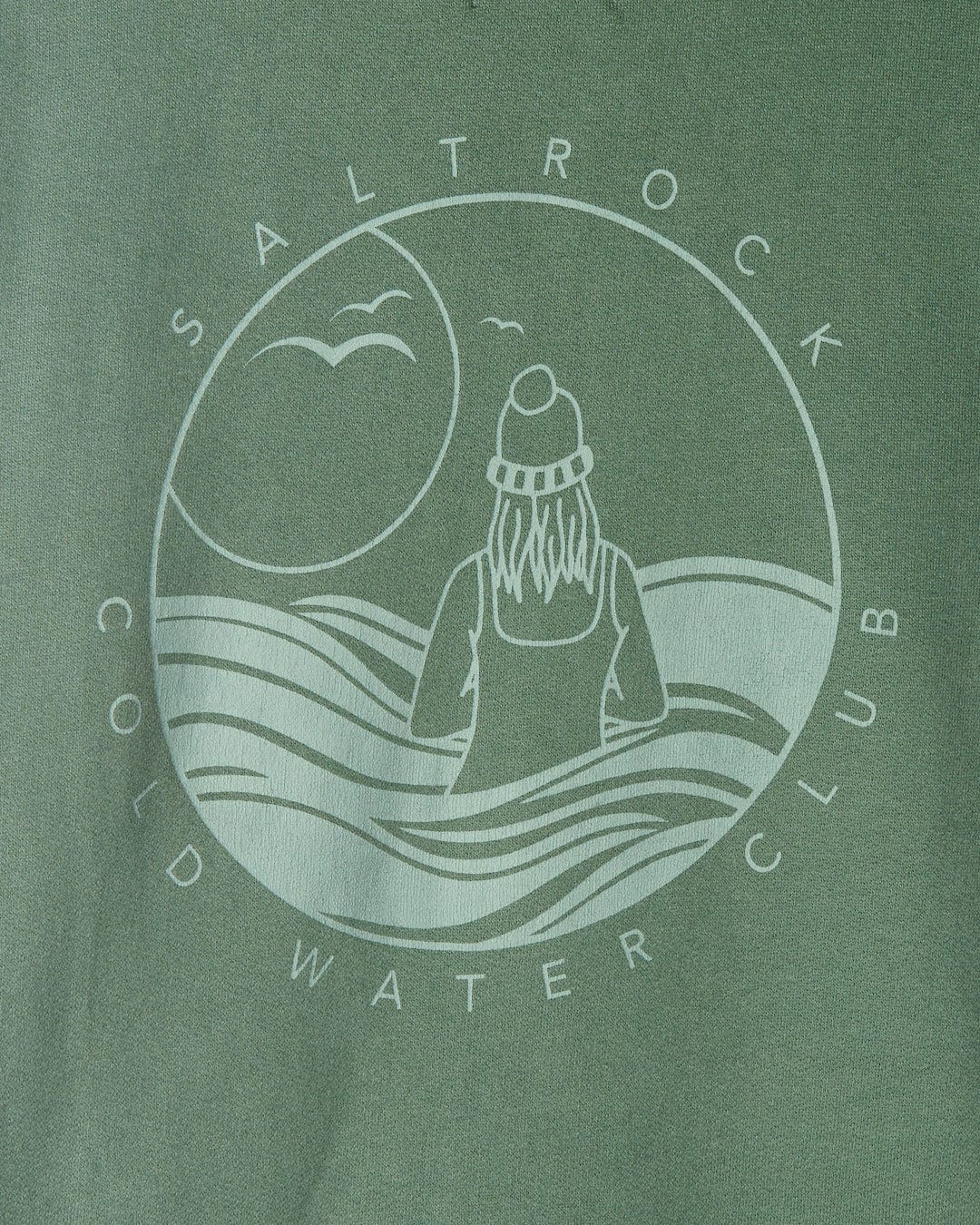 Circular logo of Saltrock's Coldwater Club featuring a stylized ocean wave design and a figure in a beanie, printed on the Ladies Zip Hoodie in Green fabric with a peached soft hand feel finish.