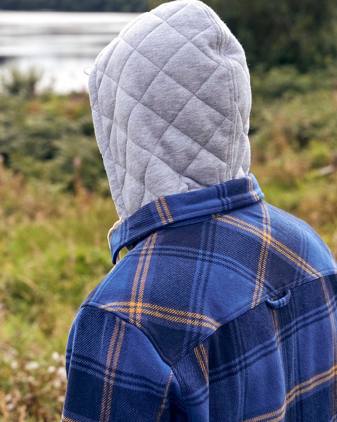 A man wearing a Saltrock Colter - Mens Hooded Longsleeve Shirt - Dark Blue hoodie.