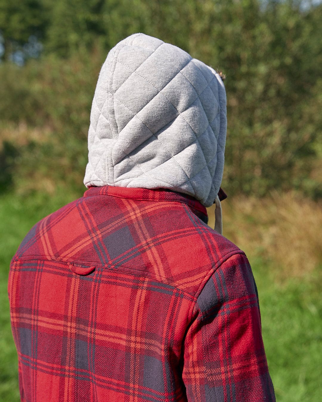 A person wearing a Saltrock Colter - Mens Hooded Shirt - Red.