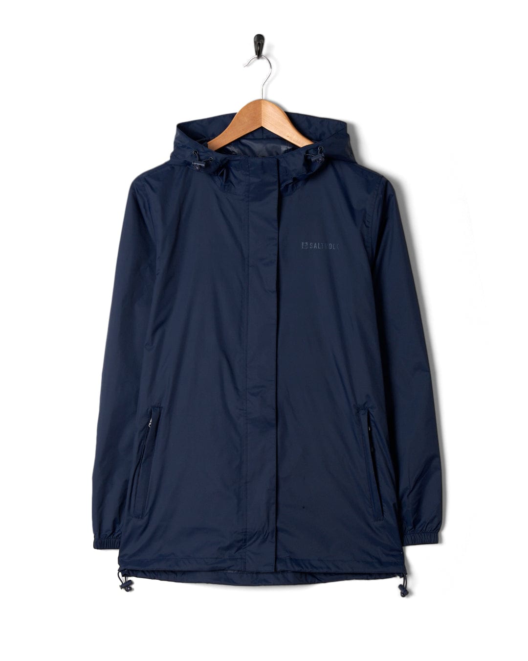 A Cooper - Womens Packable Waterproof Jacket in Blue by Saltrock hanging on a wooden hanger against a white background.