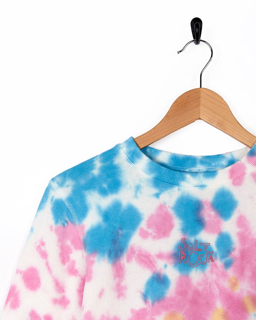 A Saltrock Coralia - Kids Tie Dye Crew Sweat - Pink shirt on a swinger.
