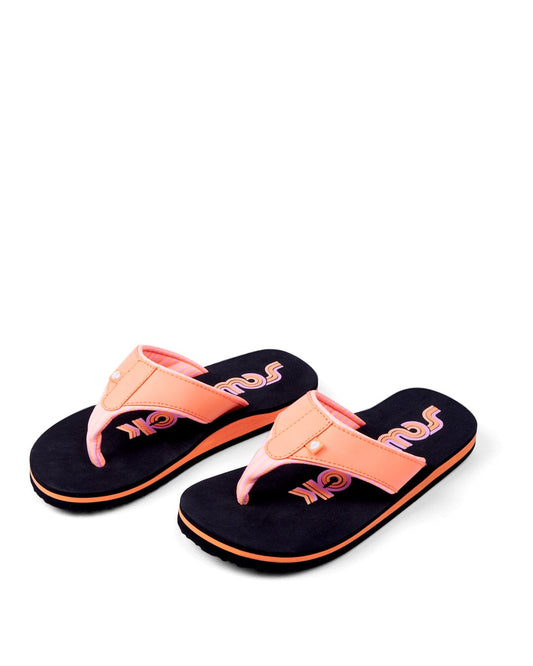 A pair of Cora Retro - Womens flip-flops in Black/Peach by Saltrock, featuring a retro logo on the sole, isolated on a white background.