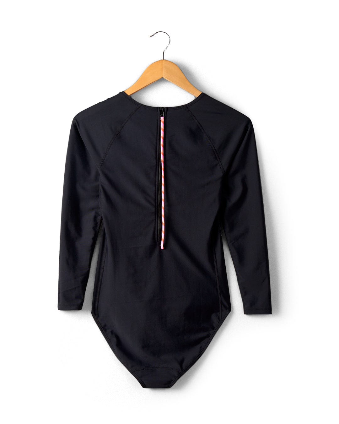 A Cora Retro - Recycled Womens Long Sleeve Swimsuit in Dark Grey with a colorful zipper down the back, hanging on a wooden hanger against a white wall.