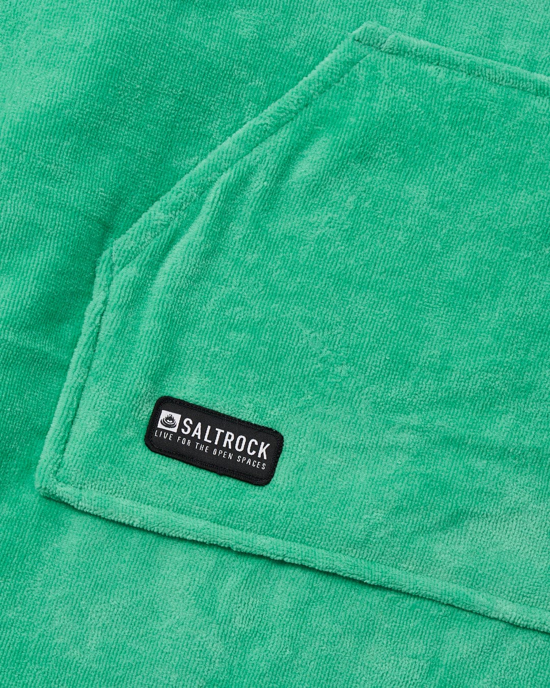 Close-up of a green absorbent cotton towelling Saltrock Corp Changing Towel - Green with a brand label.