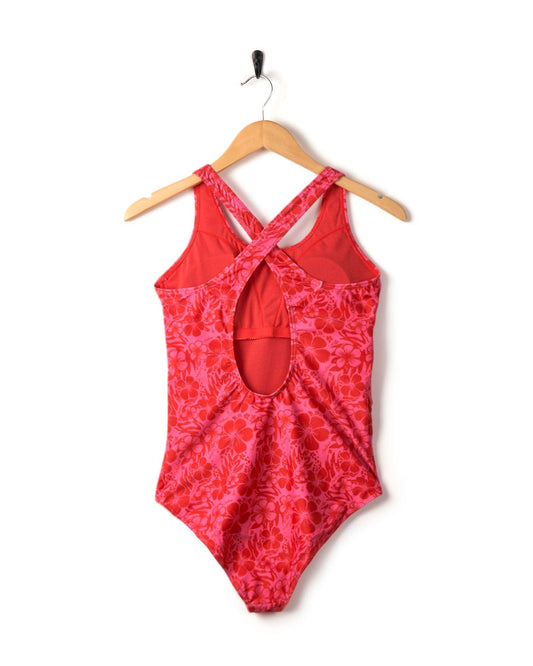 Corrine Hibiscus print one-piece swimsuit hanging on a wooden hanger against a white background.