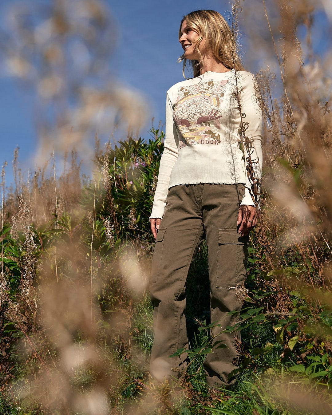 A woman standing in a field with a Saltrock Cosmic Soul - Ribbed Long Sleeve T-Shirt - Cream.
