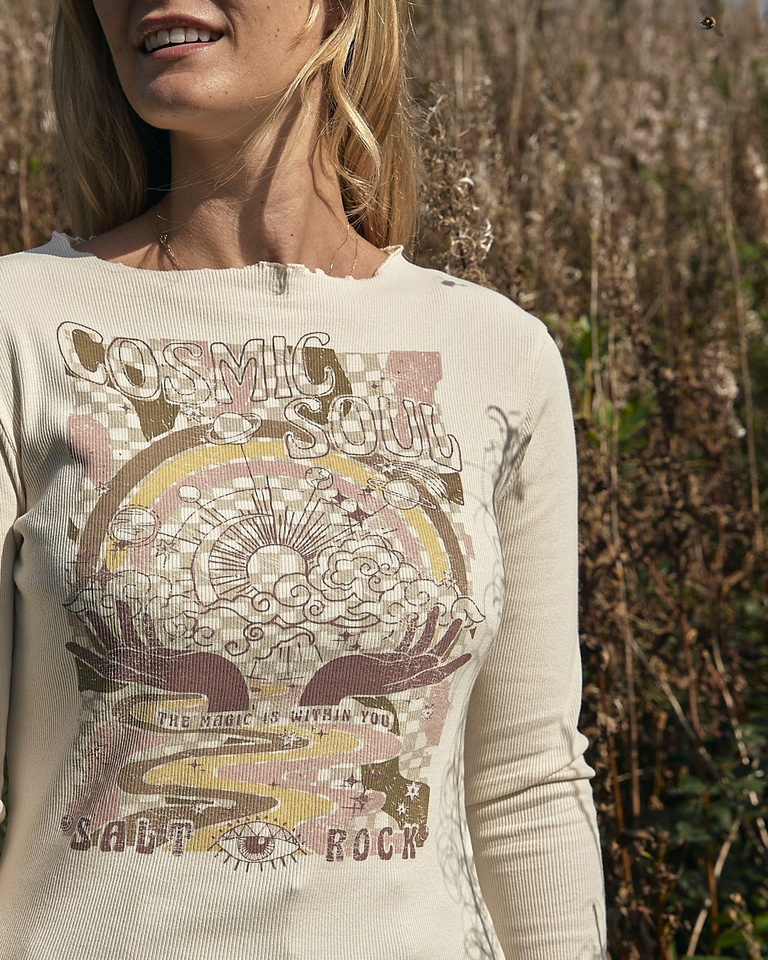A woman wearing a Saltrock Cosmic Soul - Ribbed Long Sleeve T-Shirt in Cream in a field.