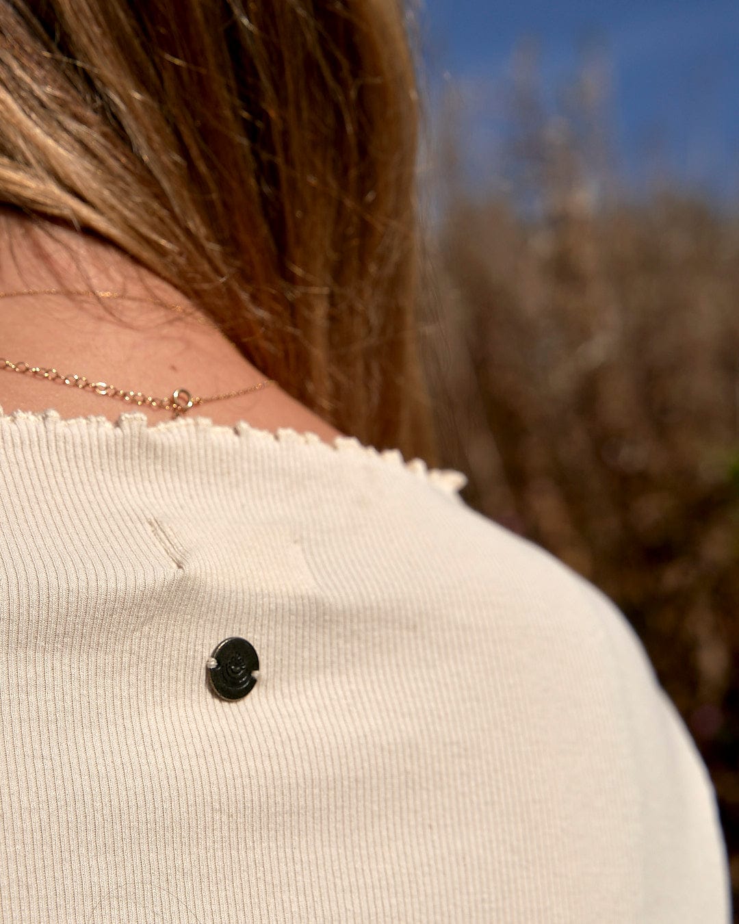 The back of a woman's Saltrock Cosmic Soul - Ribbed Long Sleeve T-Shirt - Cream with a black dot on it.
