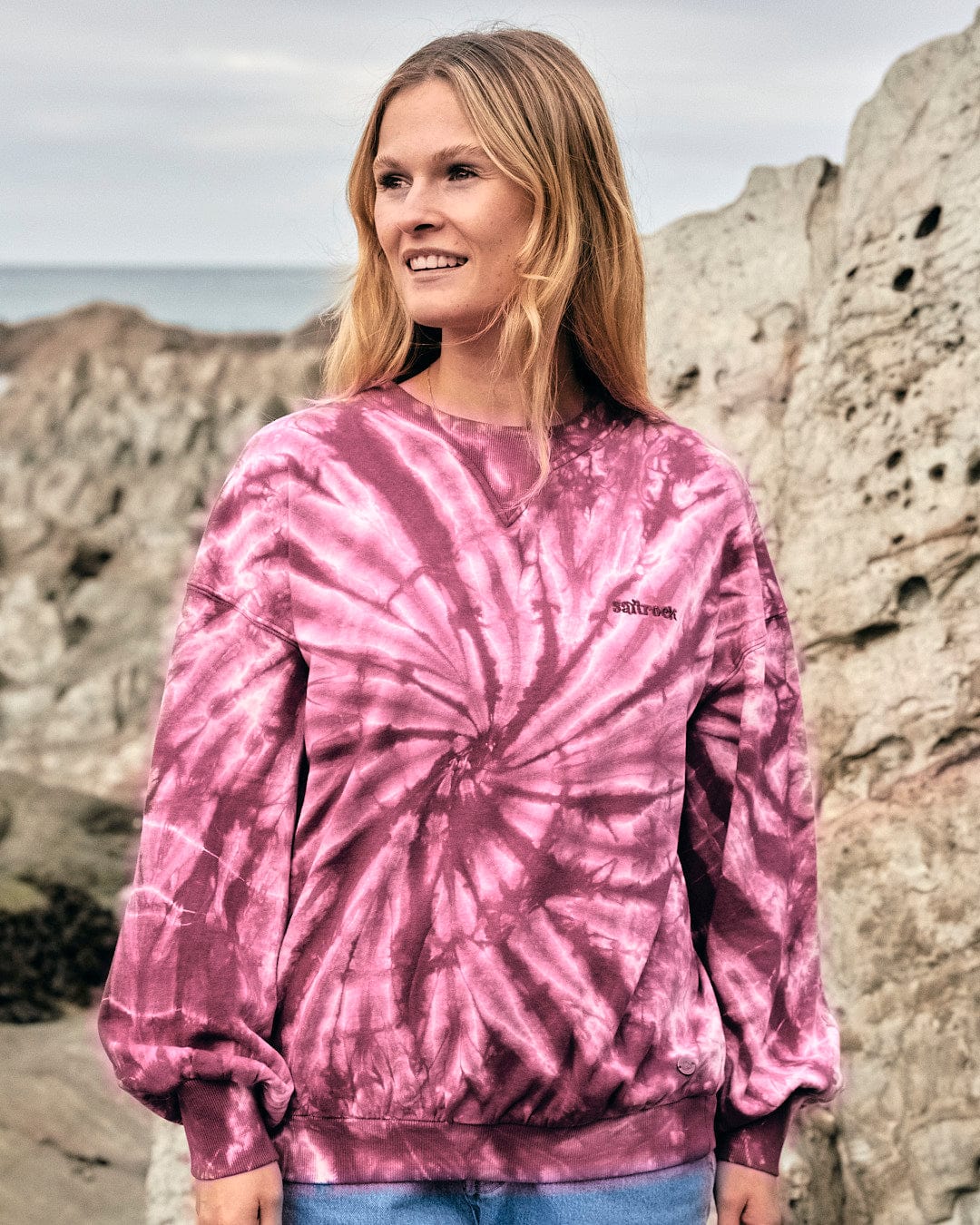 A fashionista sporting a Dawn - Womens Tie Dye Sweatshirt - Pink with Saltrock branding.