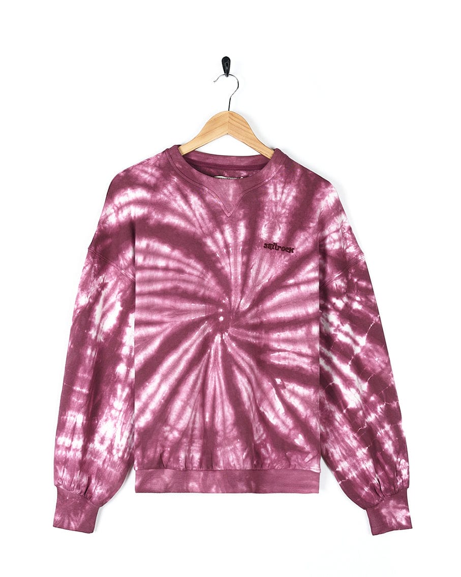 A fashionista's Dawn - Womens Tie Dye Sweatshirt - Pink featuring Saltrock branding, elegantly displayed on a hanger.
