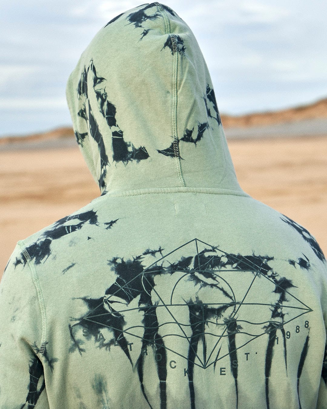 The back of a man wearing a Saltrock Dimensions - Mens Zip Tie Dye Hoodie - Green featuring Saltrock graphics.