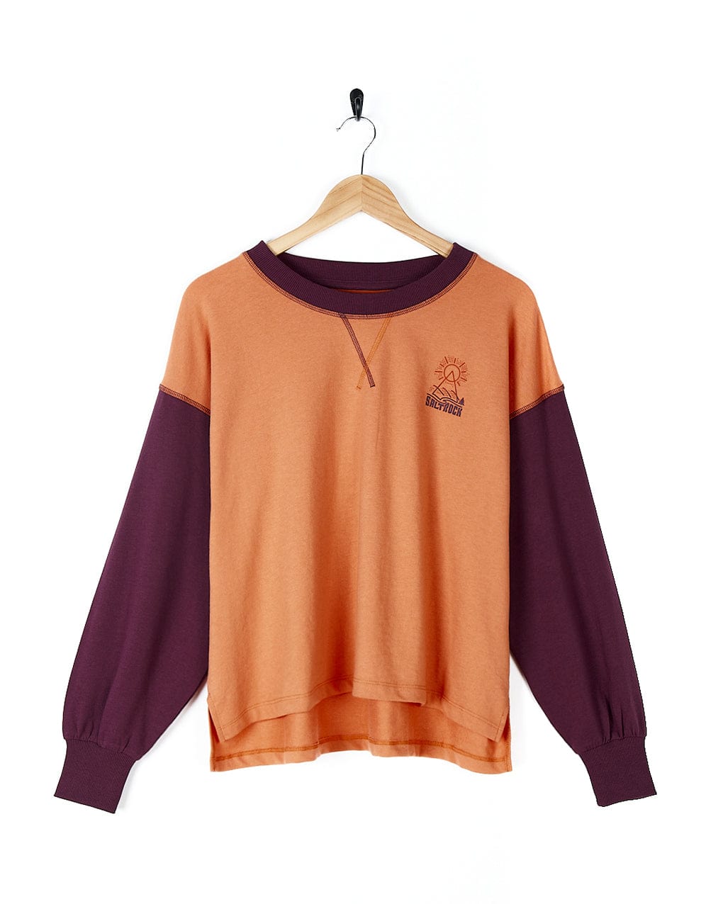 A stylish Elissa - Womens Boxy Sweat - Orange sweatshirt by Saltrock in orange and purple on a hanger.