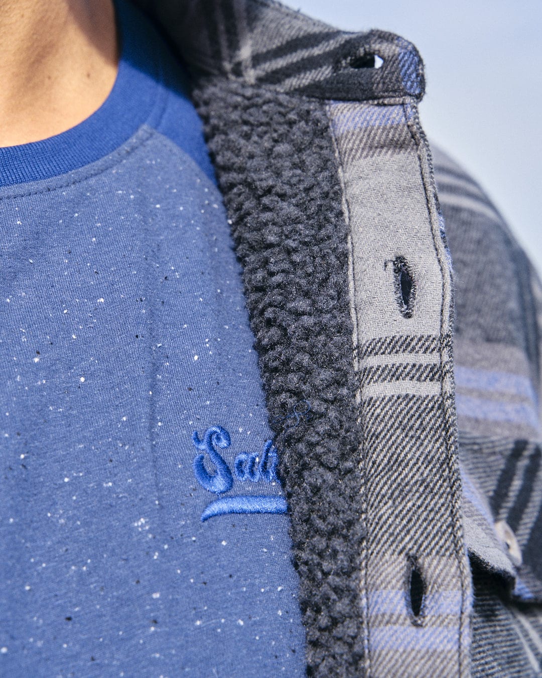 A close up of a man wearing a Saltrock Woody - Mens Sherpa Lined Shacket - Grey flannel jacket with versatile styling options.