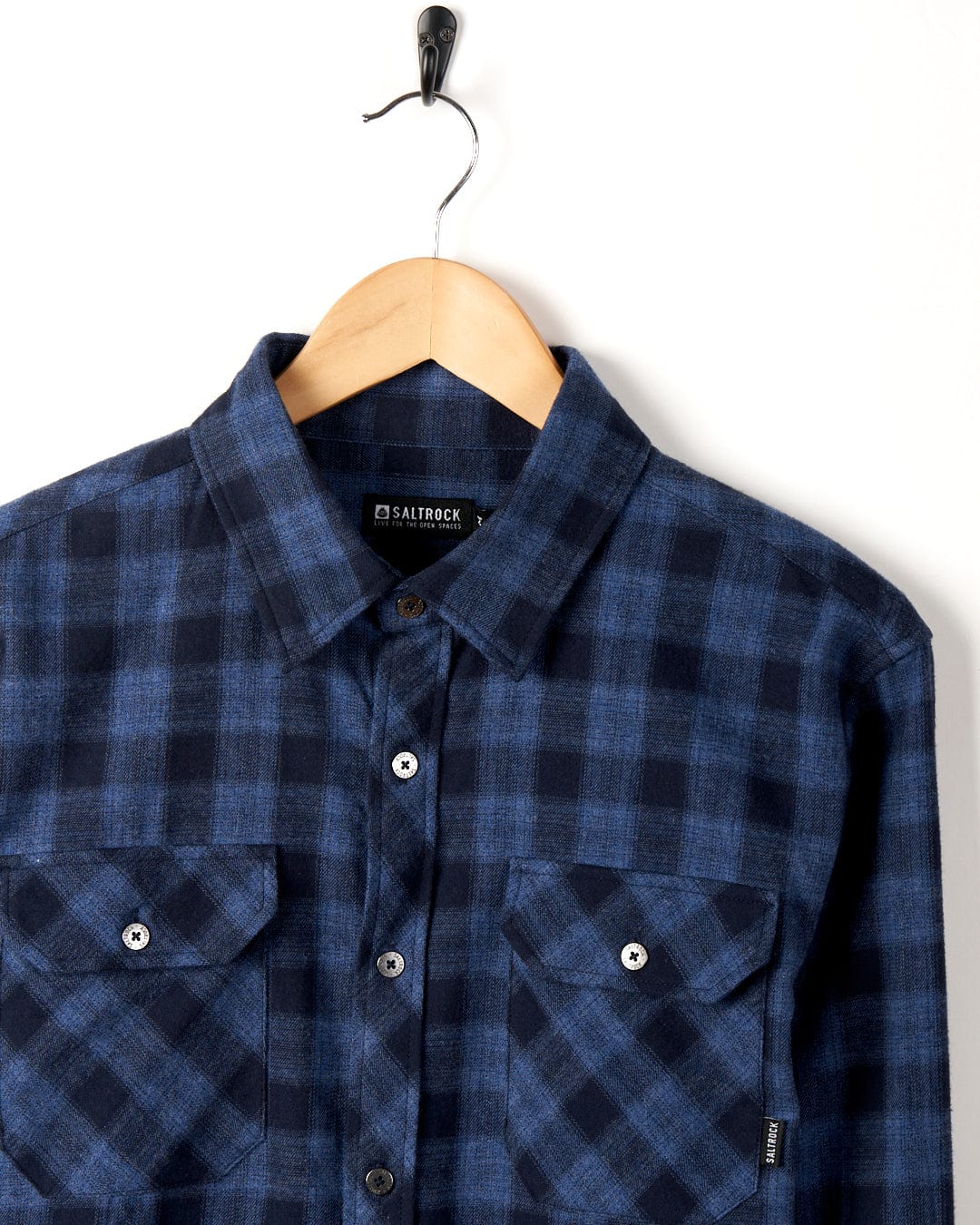 Farrow - Mens Long Sleeve Shirt - Blue by Saltrock on a wooden hanger against a white background.