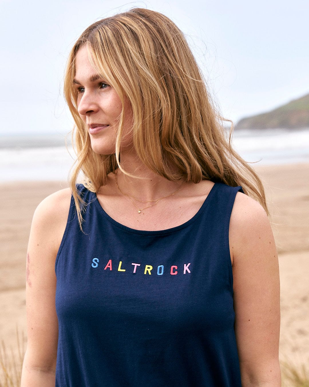 A woman wearing a Saltrock tank top with the word "Flax - Womens Tie Vest Dress - Blue" on it.