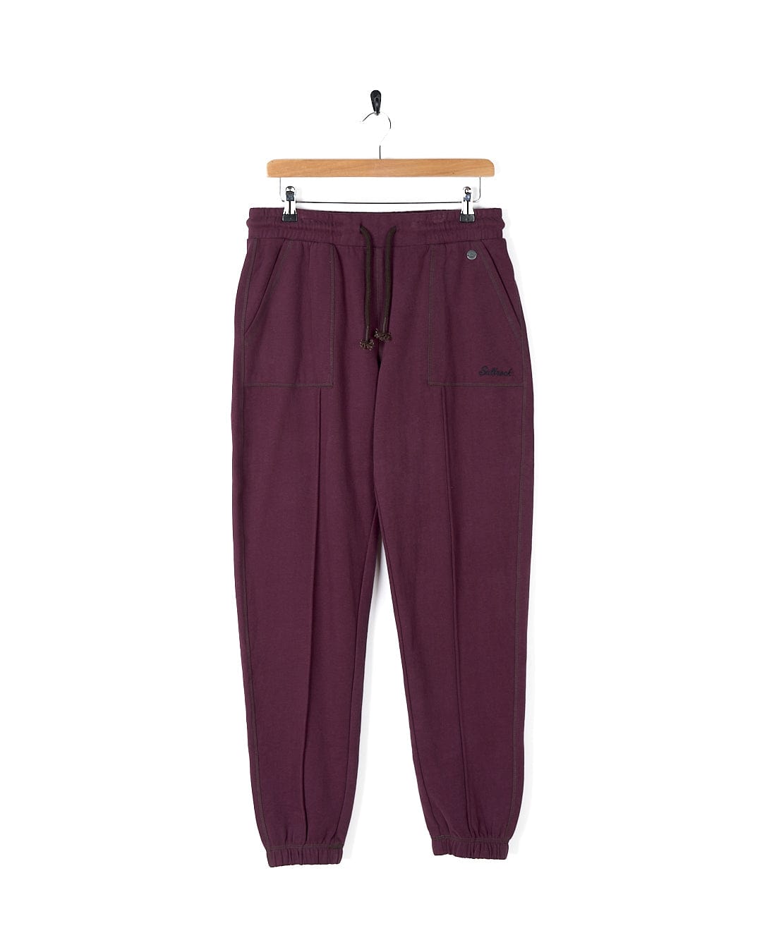 A stylish pair of Saltrock Flo - Womens Jogger - Purple sweatpants hanging on a hanger.