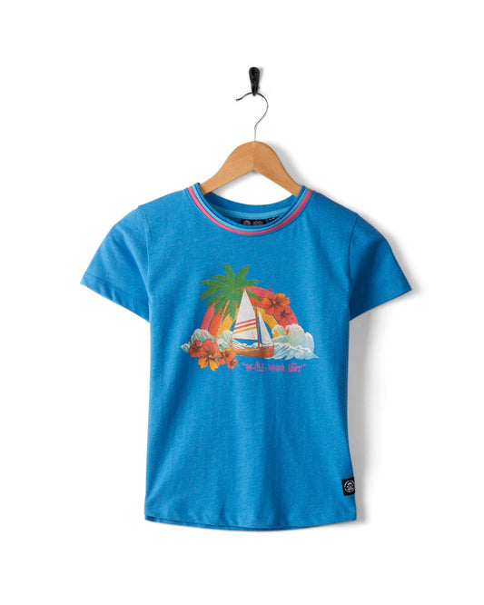 Floral Lost Ships - Kids Recycled T-Shirt - Blue, featuring a tropical sailboat graphic, palm trees, flowers, and the text "Sail Away," designed by Saltrock using recycled materials, hanging on a wooden hanger against a white background.