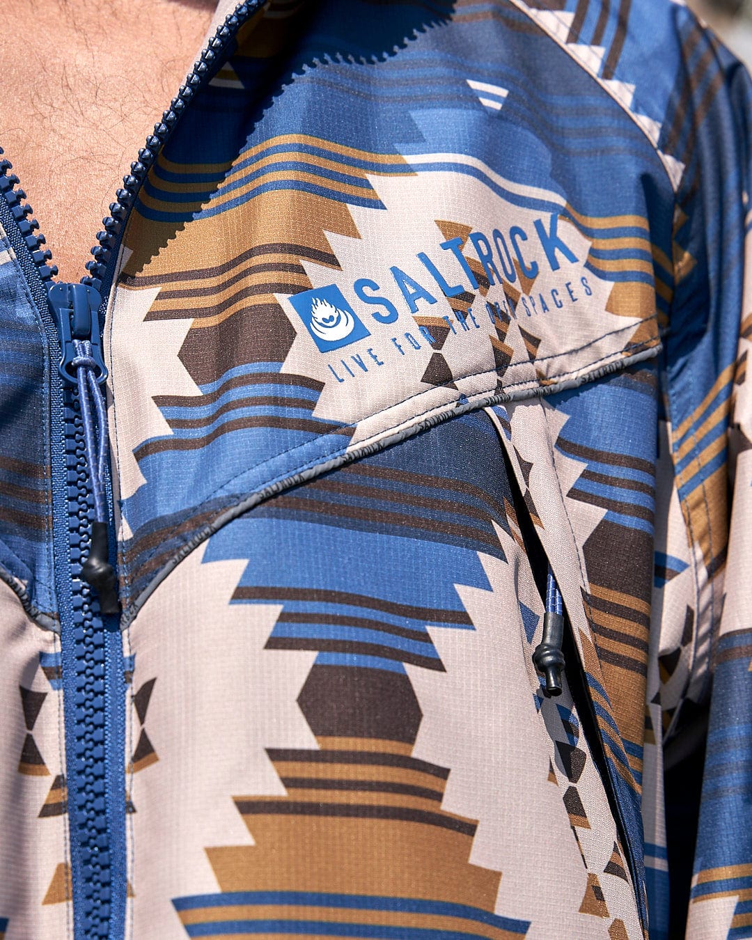 A man wearing a Saltrock Four Seasons Changing Robe - Aztec jacket.