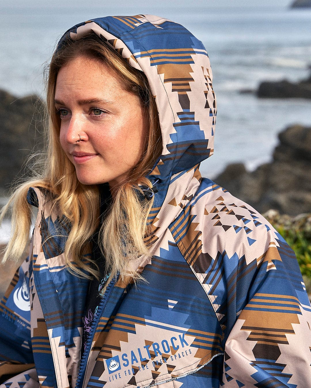 A woman wearing a Saltrock Four Seasons Changing Robe - Aztec.