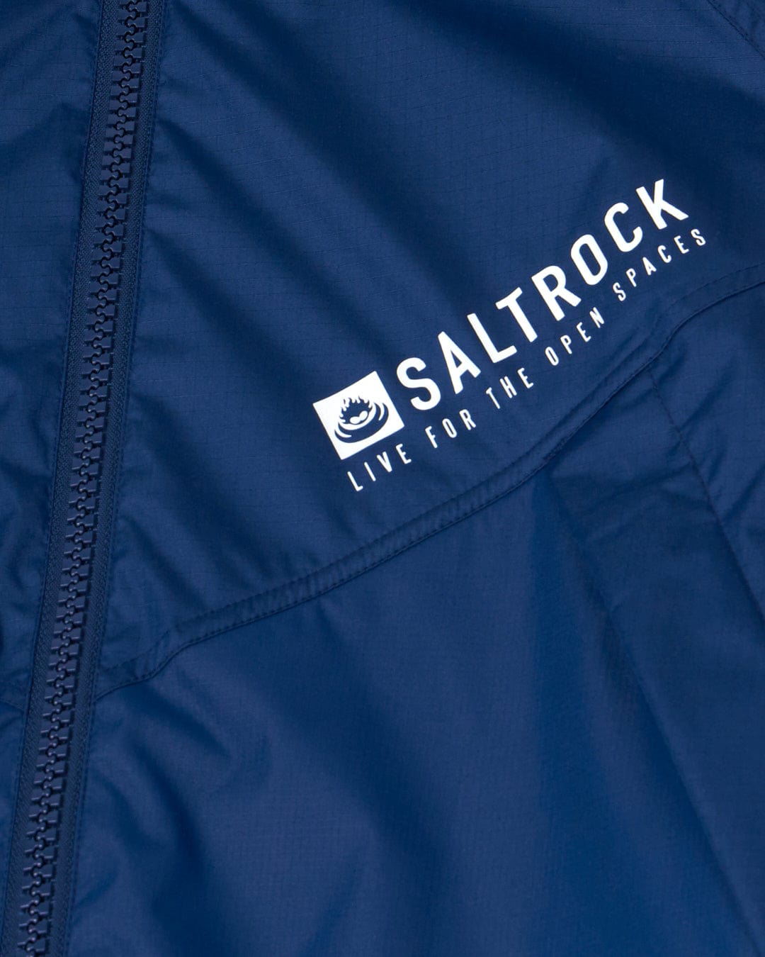 Close-up of a Saltrock Recycled Four Seasons Changing Robe - Blue, showing the brand logo and the slogan "live for the open spaces" on the chest.