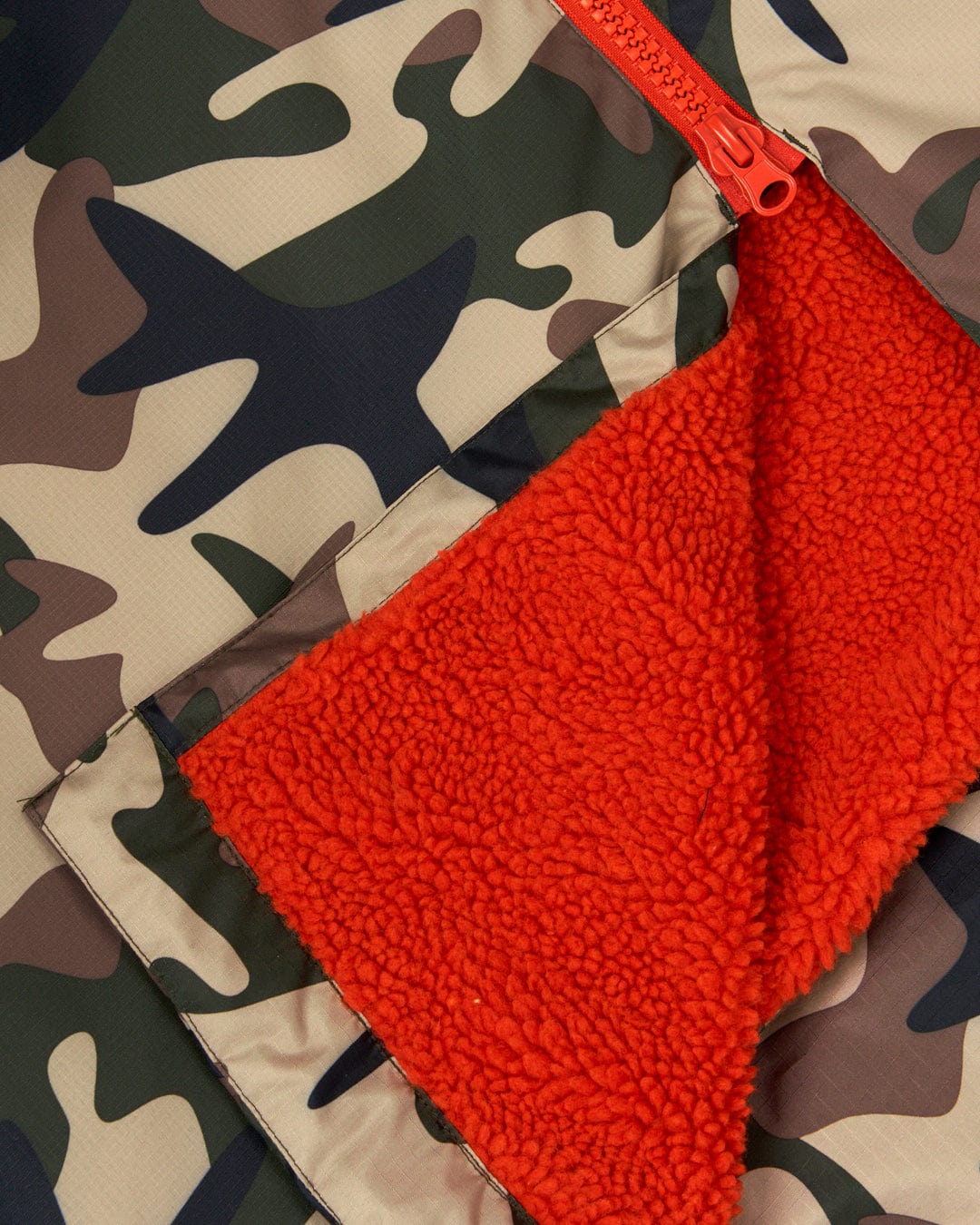 Saltrock's Recycled Four Seasons Changing Robe in Brown Camo with an orange zipper pouch partially open, revealing a soft, orange interior lining of a waterproof changing robe.