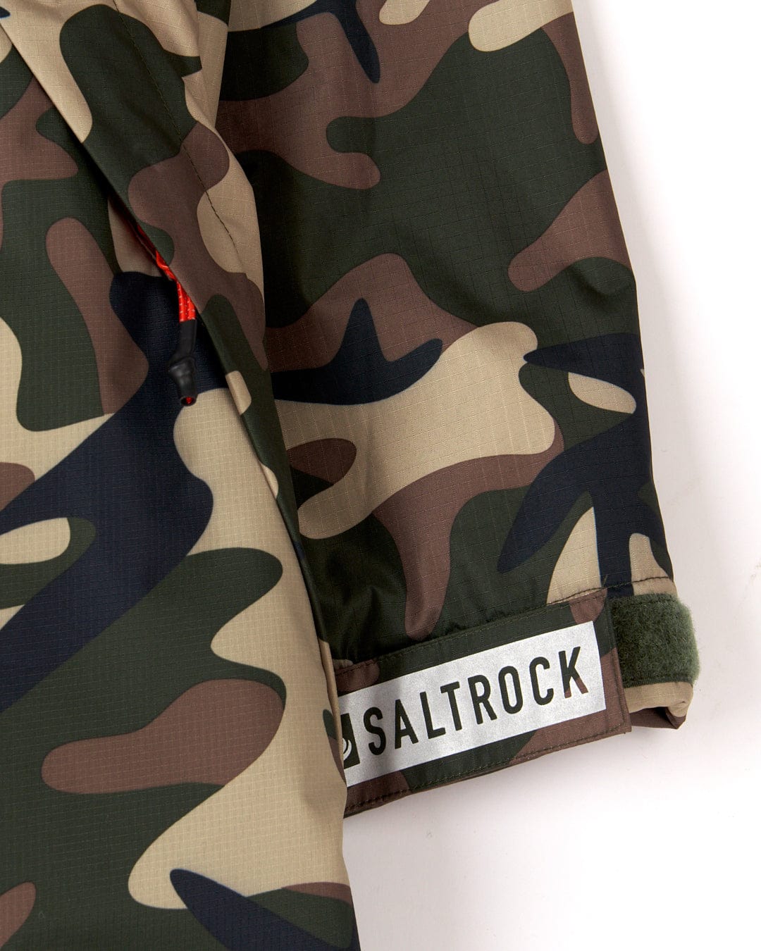 Close-up of a camouflage fabric with a Saltrock brand tag on a Recycled Four Seasons Changing Robe in Brown Camo.