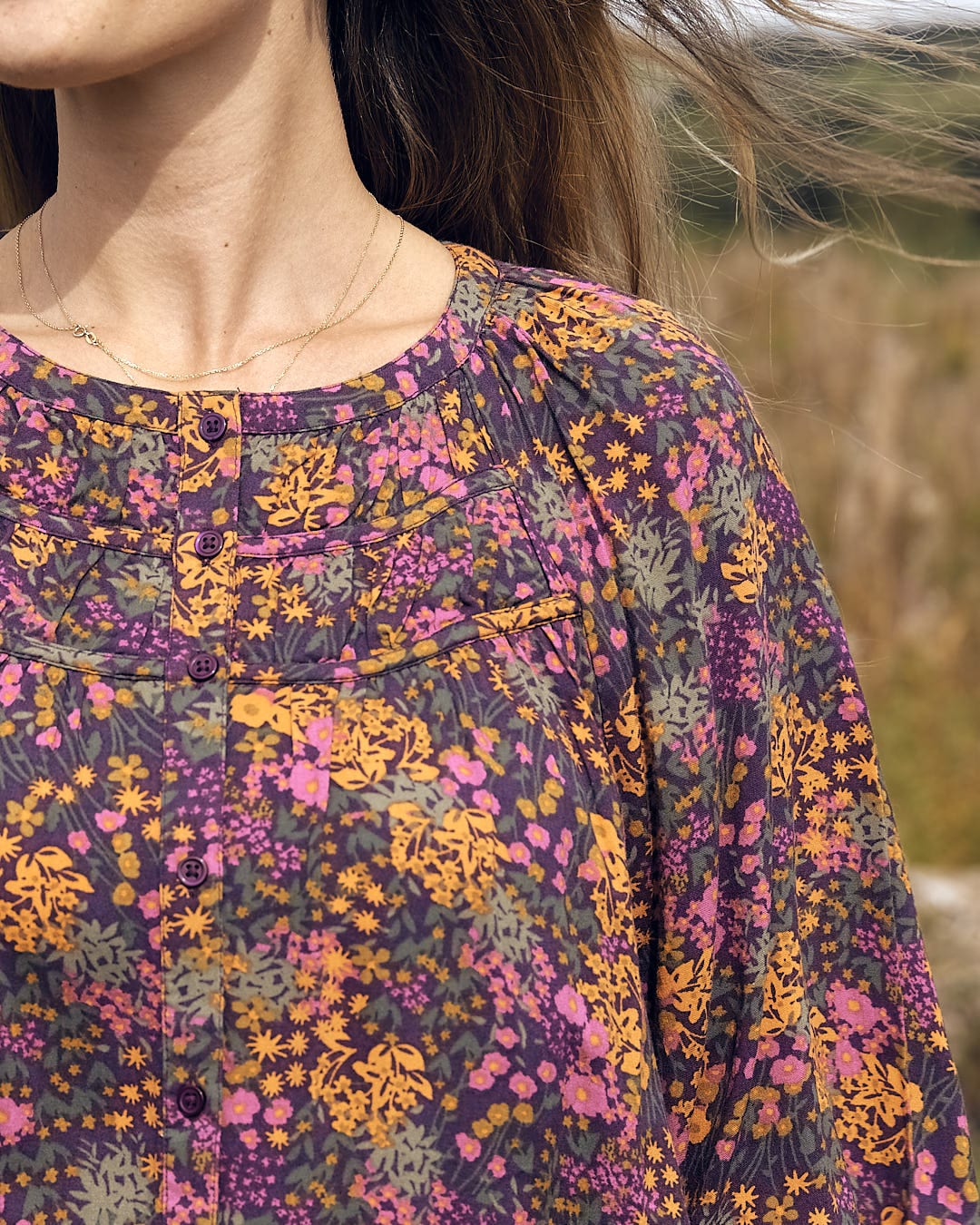 A woman in a Saltrock Garnet - All Over Print Blouse - Orange standing in a field.