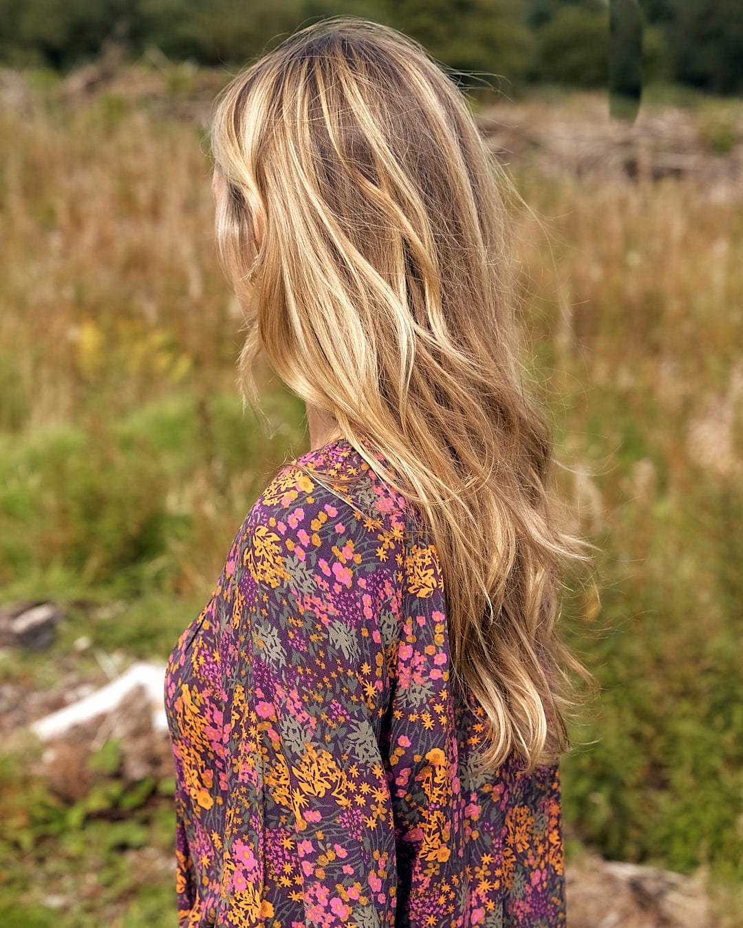 A woman in a Saltrock Garnet - All Over Print Blouse - Orange standing in a field.