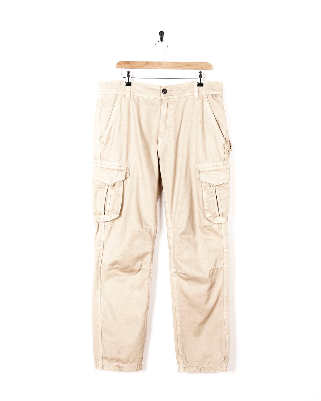 A pair of Saltrock Godrevy - Mens Cargo Trouser - Cream hanging on a hanger.