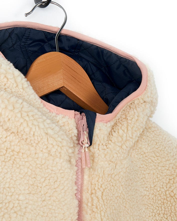 A girl's Saltrock beige sherpa jacket with a pink zipper and fur lining.