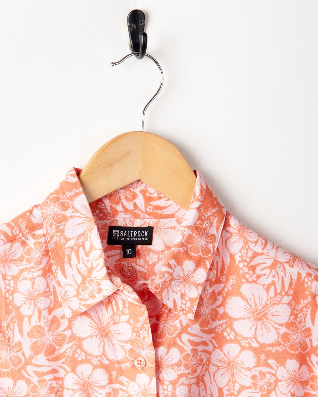 Saltrock's Hibiscus - Womens Tie Front Shirt in Orange on a wooden hanger against a white background.
