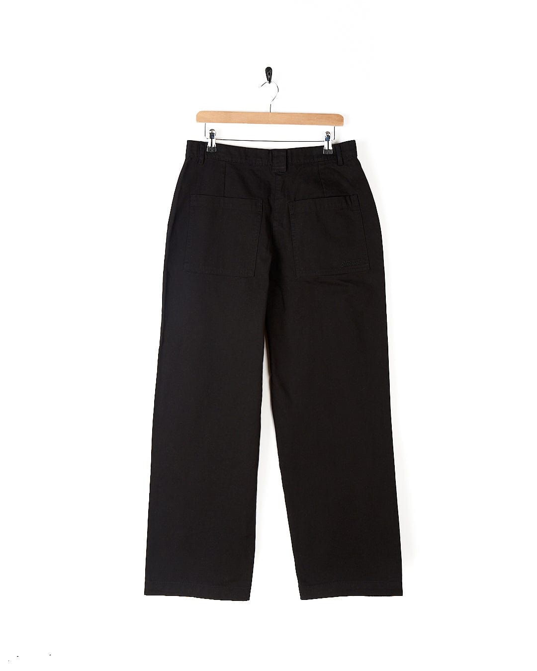 A pair of Saltrock Hilda Twill - Womens Trouser - Black hanging on a hanger.