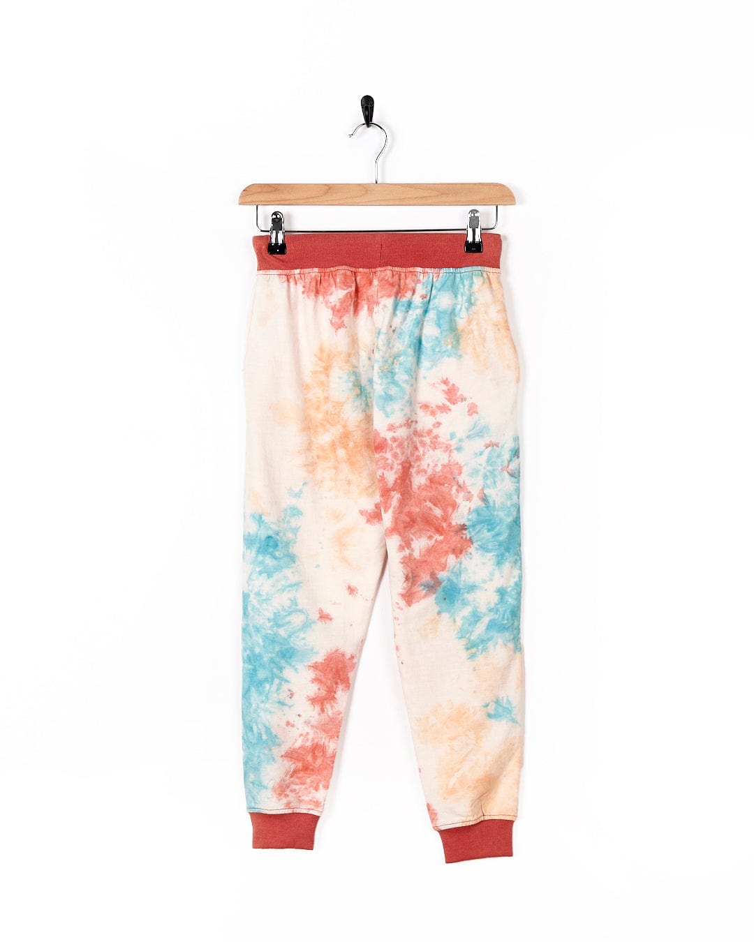 A pair of Saltrock Hippy - Kids Tie Dye Jogger - Multi hanging on a hanger.