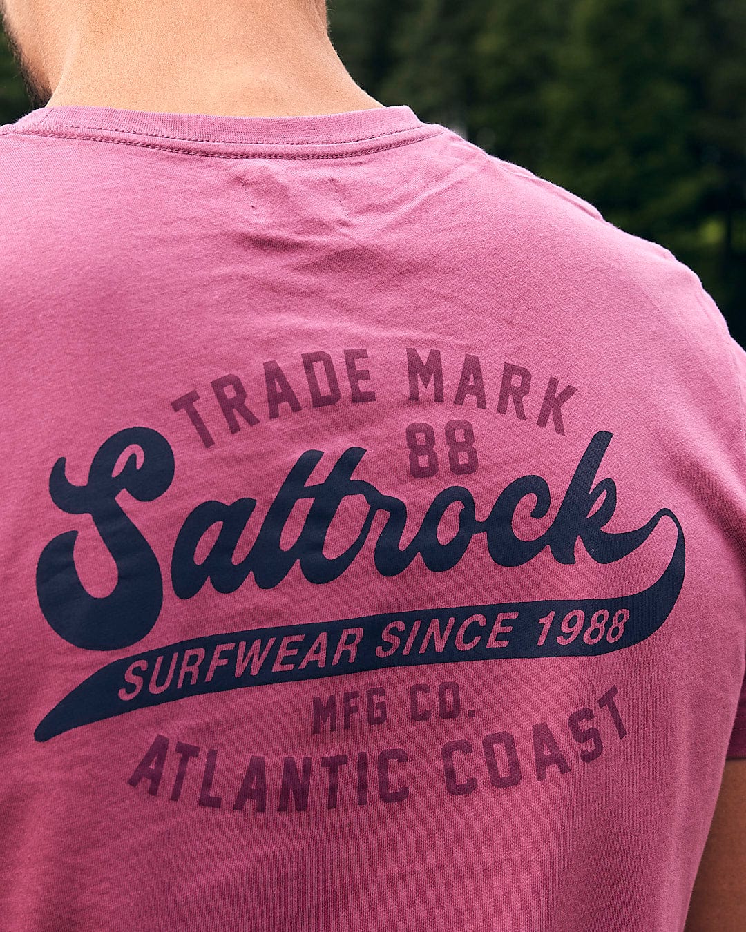 A man wearing a Saltrock Home Run - Mens Short Sleeve T-Shirt - Dark Pink.