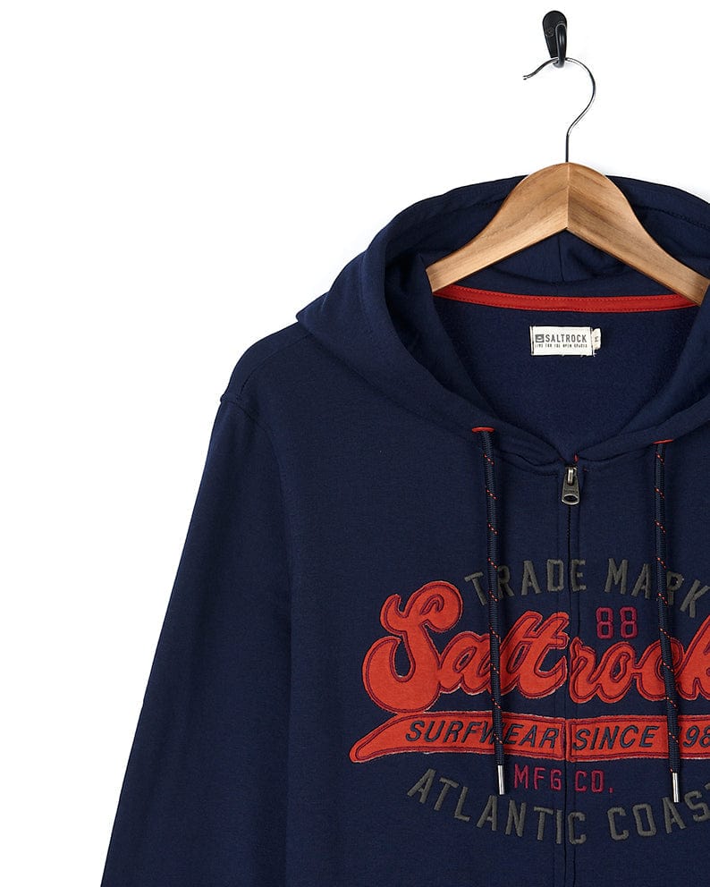 A dark blue Home Run - Mens Zip Hoodie with contrast red chenille textured Saltrock branding.